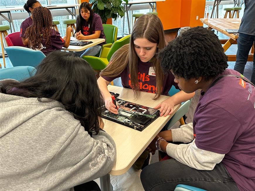 Three IT students working on a computer repair at Lenovo