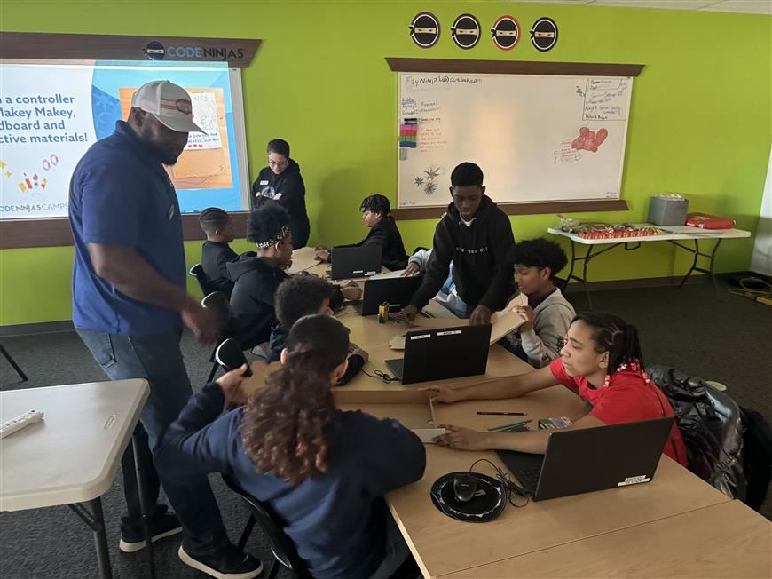  A group of students  participating in a coding activity at Code Ninja's workspace.